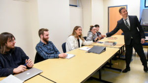 Professor Ian MacDonald, who also serves as interim dean of the School of Mathematics and Sciences, passes the microphone to students as they speak with people who work in cybersecurity.