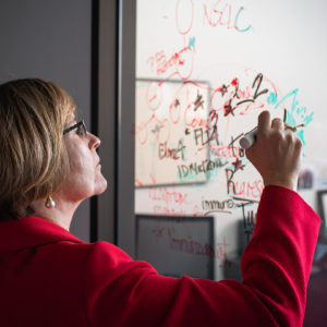 Patrice Milos, Saint Rose Alumni, writing algorithms on her office window