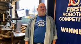 Rich Kissane G'90 with FIRST Robotics banner